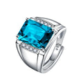 Adjustable open geometric copper ring with colourful rhinestone setting on a finger.