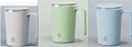 White automatic electric stirring cup with stainless steel finish and minimalist design on a table.