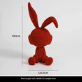 Green suede blindfold rabbit resin table ornament on a wooden surface.