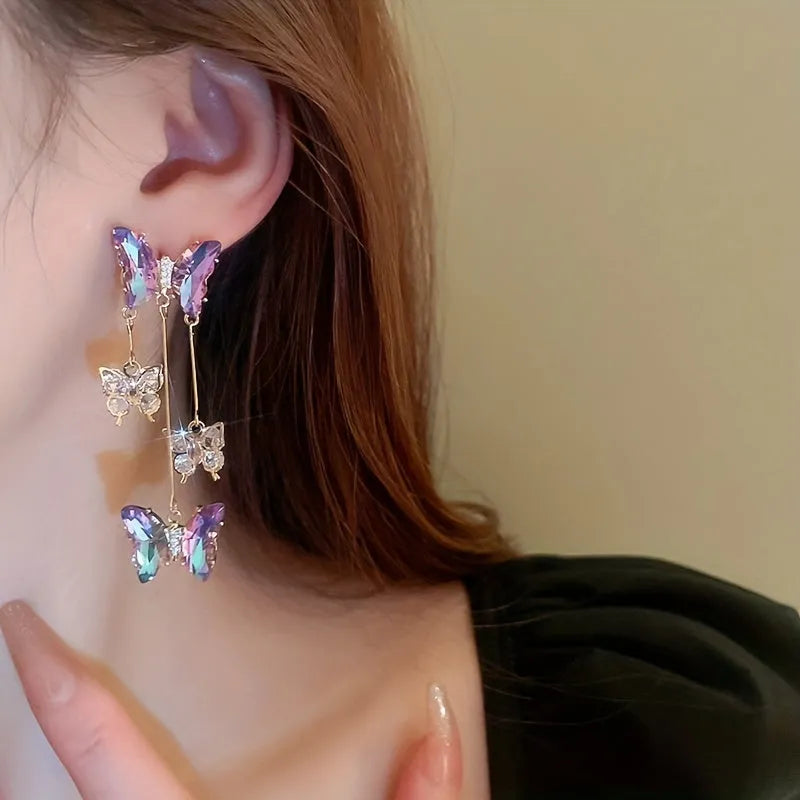 Blue purple butterfly-shaped drop earrings with crystal flowers and a metal tassel.