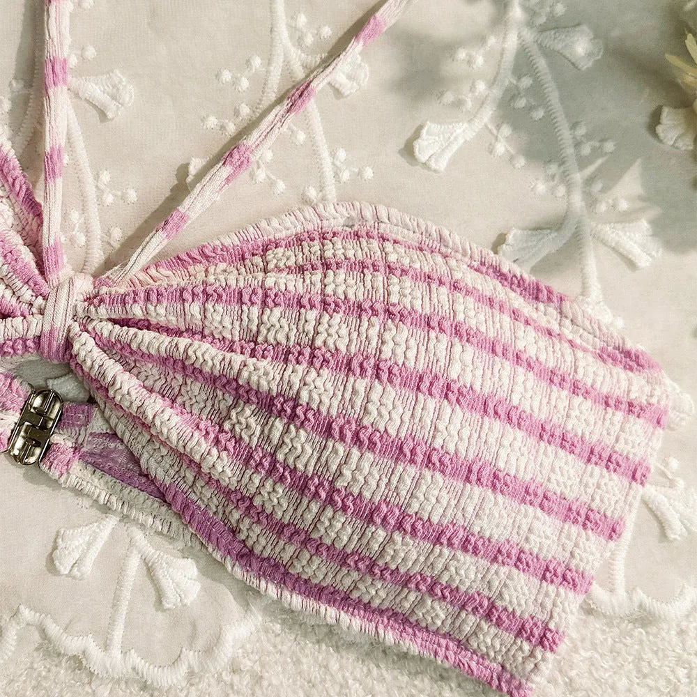Women's pink and black striped printed bikini swimsuit on a hanger.