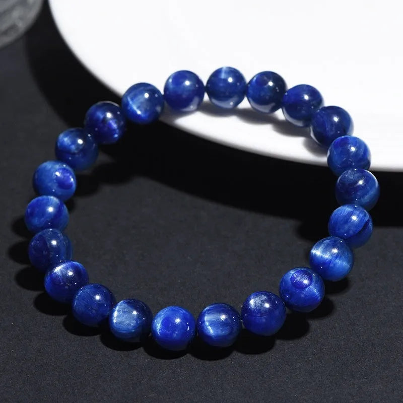 Blue crystal ball bracelet with geometric design and Ruyi motif on a white background.