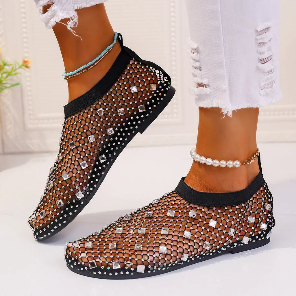 Women's flat sandals with colourful rhinestones on a breathable mesh upper and rubber sole.