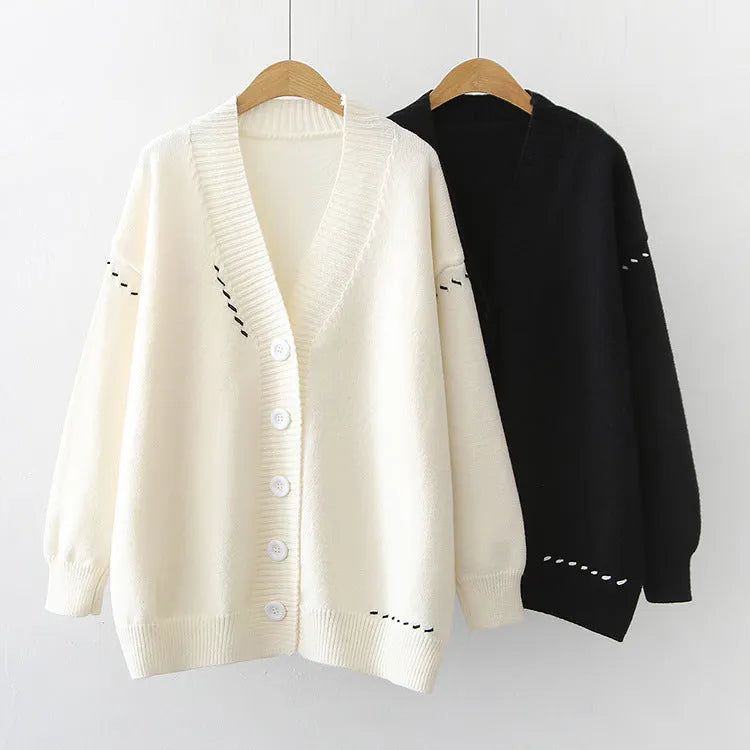Women's loose-fit black knitted cardigan top coat with long sleeves on a hanger.