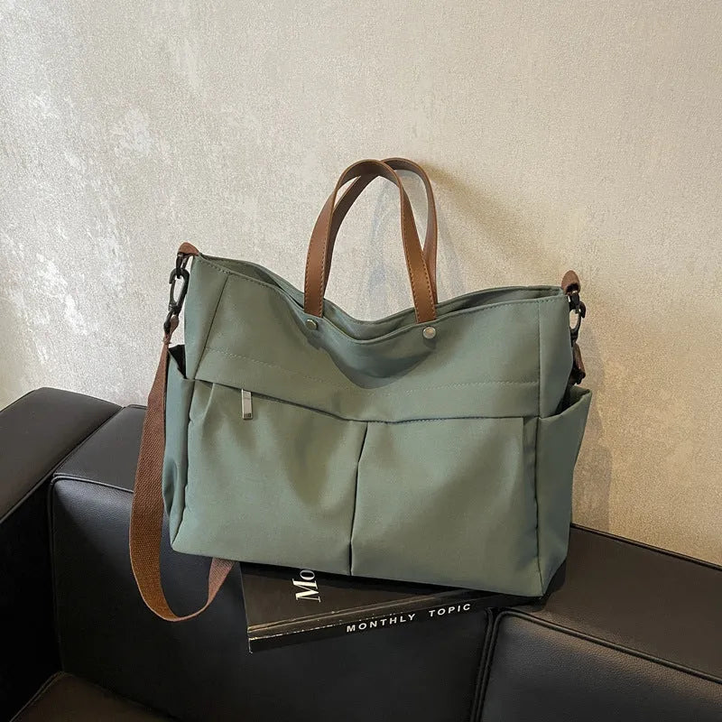Nylon crossbody bag with adjustable strap in black colour, showing tote design with 39cm length