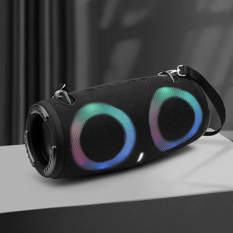 War Drum portable Bluetooth speaker with coloured RGB lights on a table outdoors.