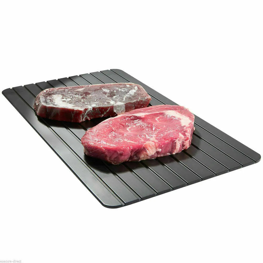 Black rectangular aluminium fast defrost tray for thawing frozen food on a kitchen counter.