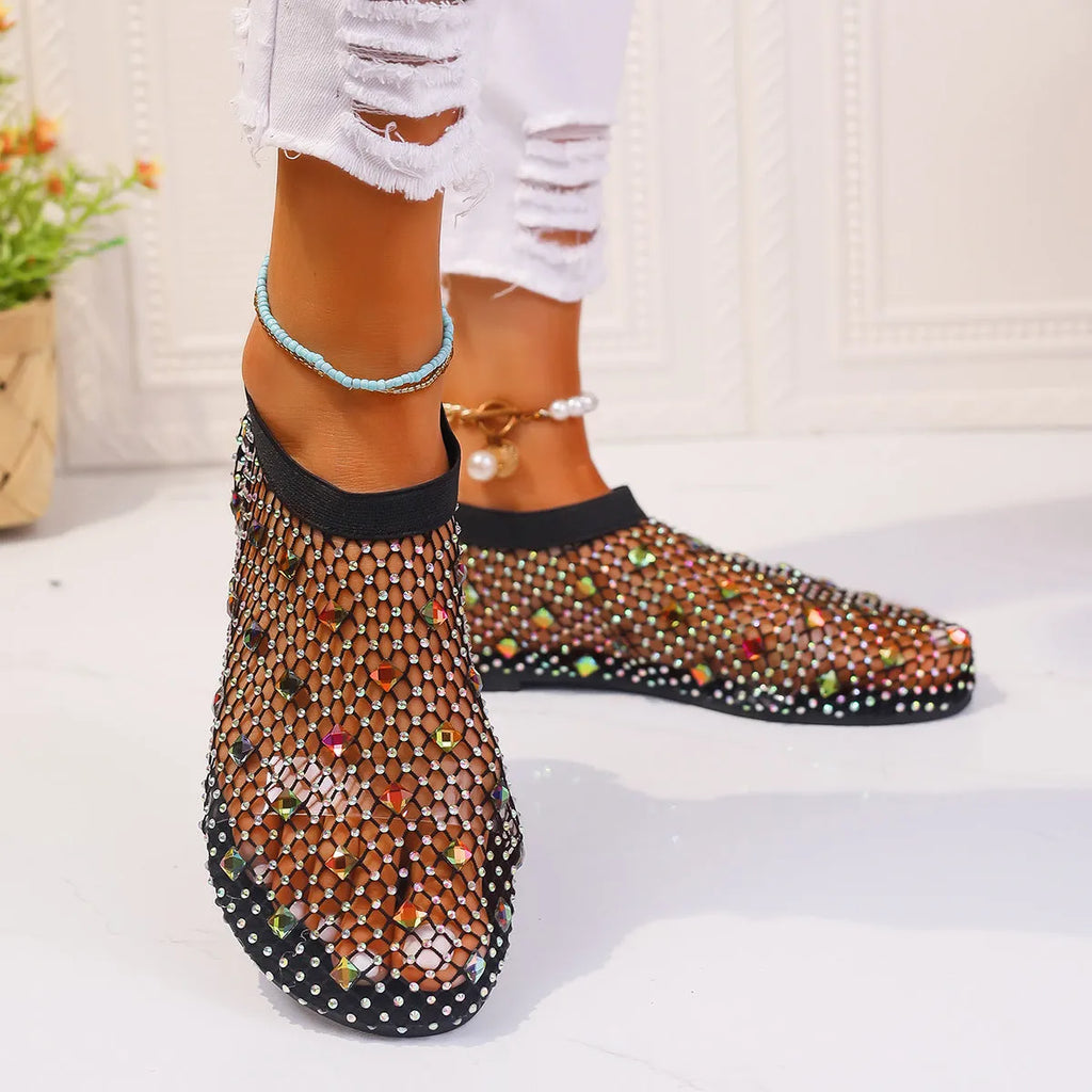 Women's flat sandals with colourful rhinestones on a breathable mesh upper and rubber sole.