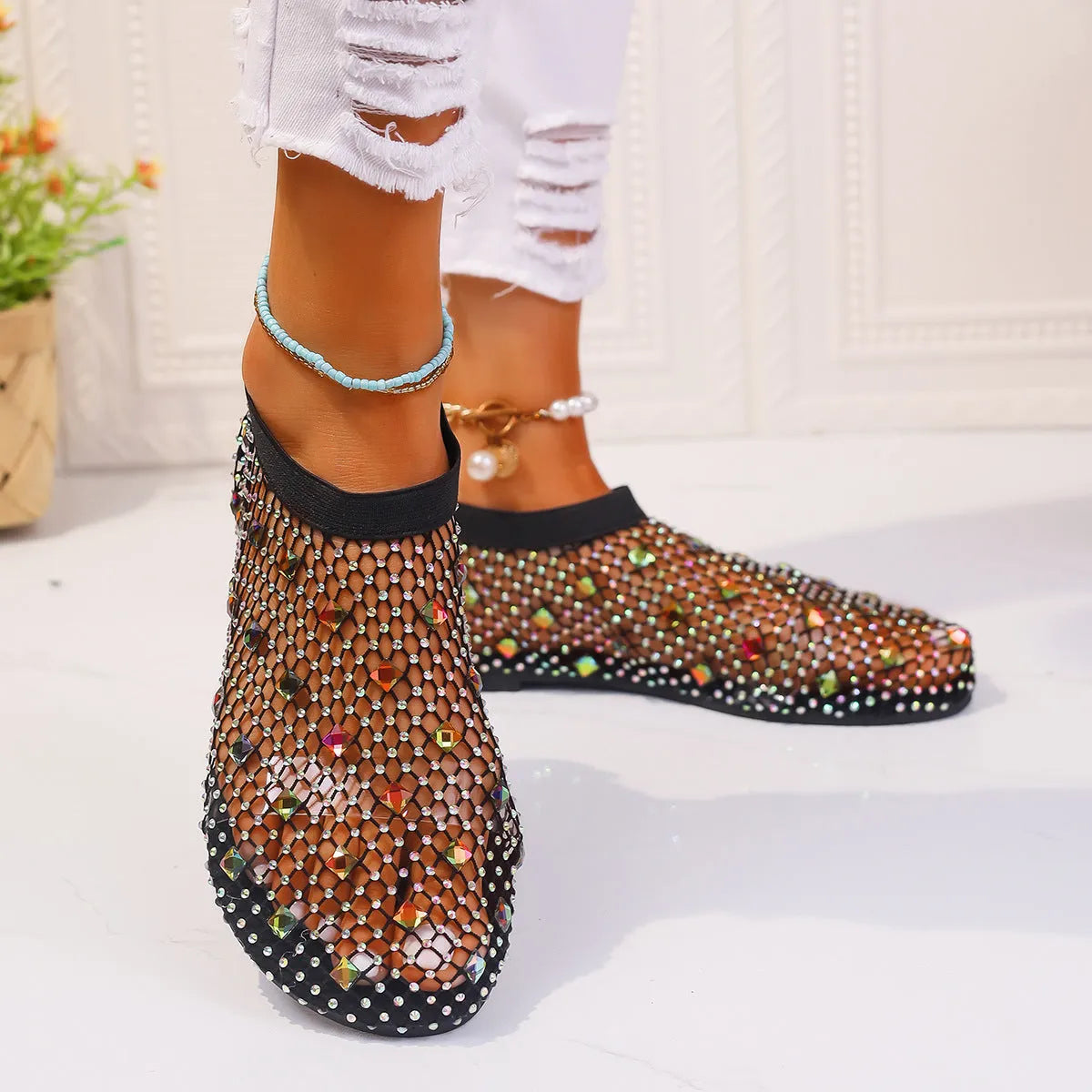 Women's flat sandals with colourful rhinestones on a breathable mesh upper and rubber sole.