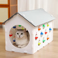 Plastic house-shaped cat scratch board with integrated bell ball toy for feline enrichment