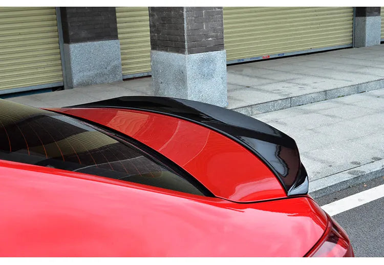 Bright black aftermarket tail trim spoiler for a Mazda 3 car rear bumper.