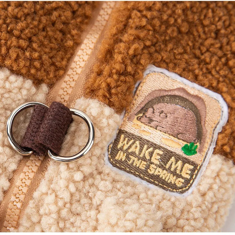 Colour-block pet fleece jacket with squirrel patch, leash ring, and pockets in green, brown, and beige on a small dog.