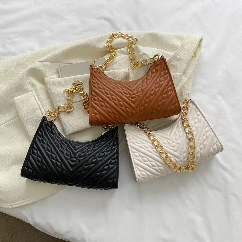 Vertical brown PU leather women's shoulder bag with a pleated front, chain strap, and soft handle.