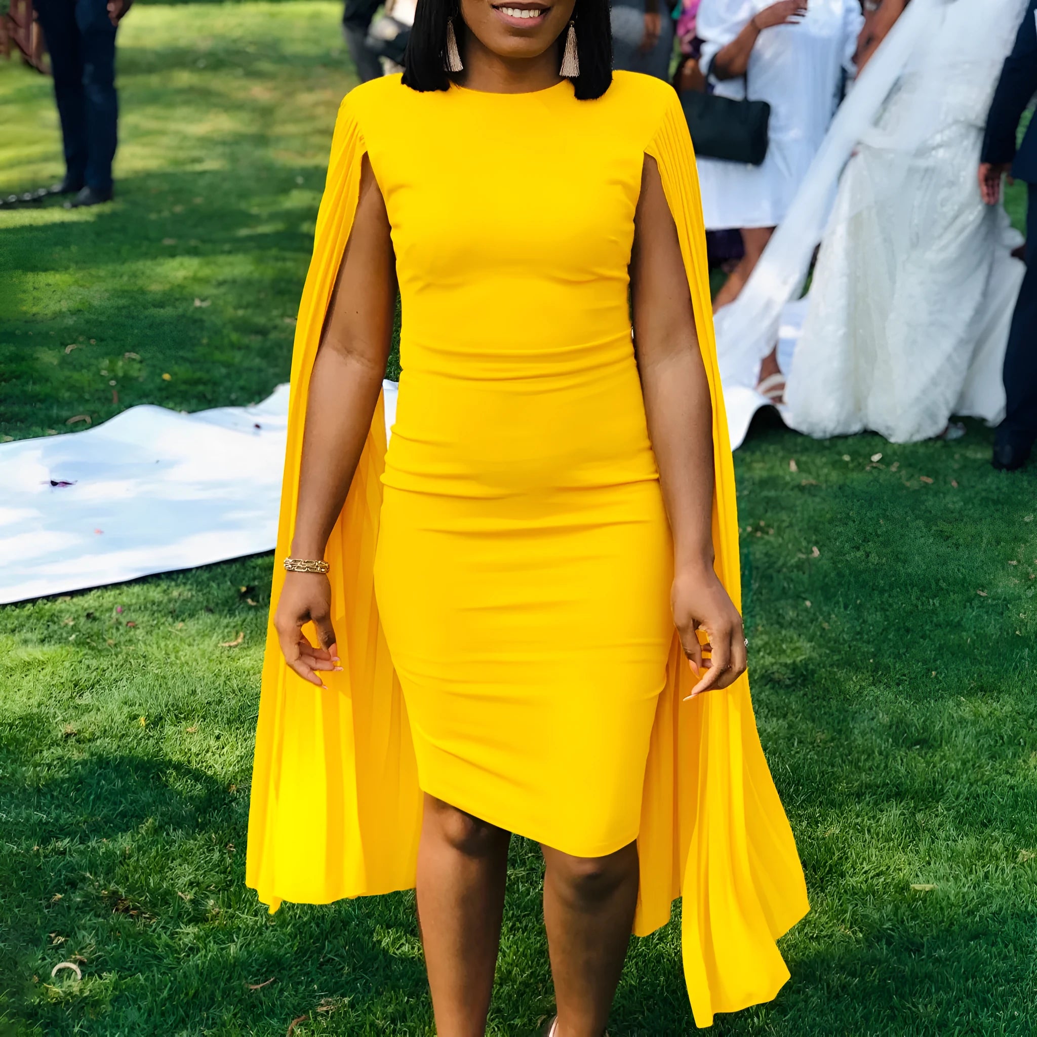 Yellow formal evening gown with round neck, long sleeves, high waist, and pleated skirt on a mannequin.