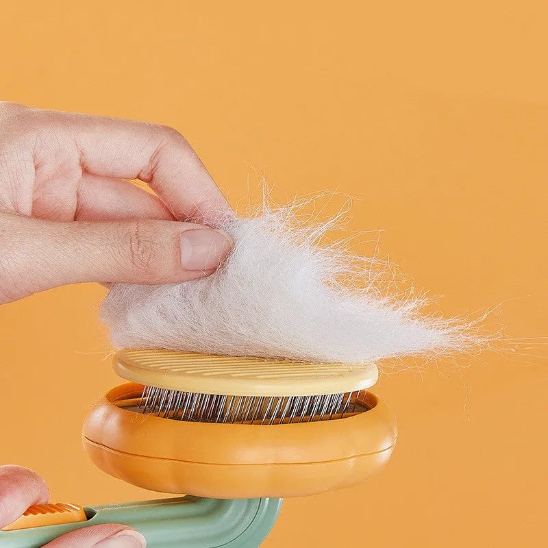 Hand-held pet grooming brush with curved stainless steel teeth in pumpkin colour option