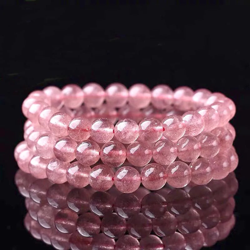 Women's strawberry quartz crystal bracelet with polished beads in three size options on wrist