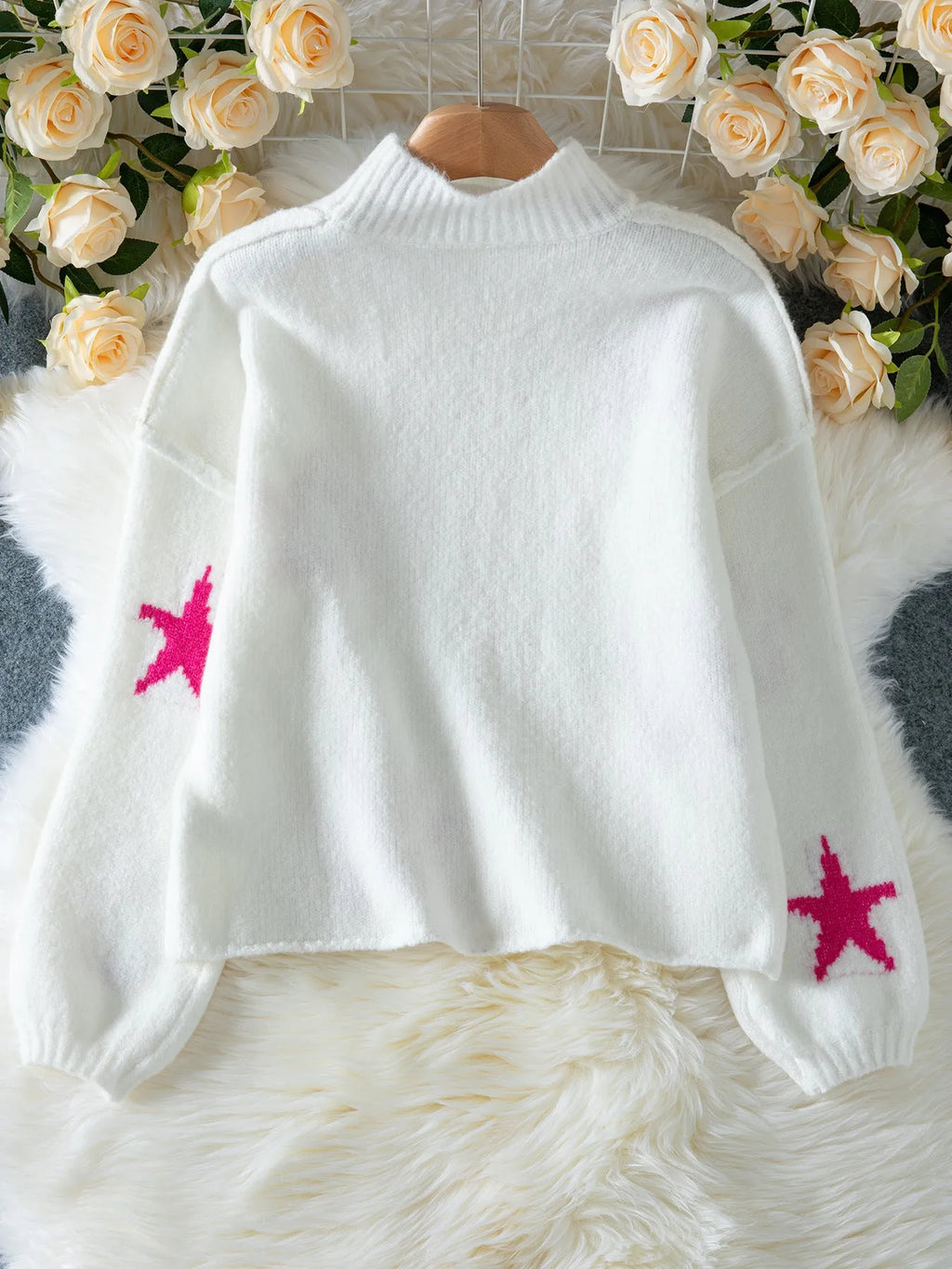 White women's loose turtleneck pullover with a black five-pointed star pattern on the front.