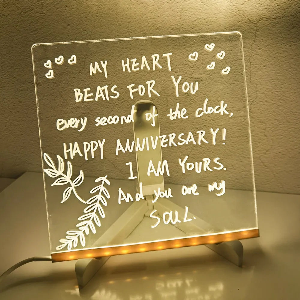 Acrylic LED message board night light on a desk with colourful handwritten notes glowing softly.
