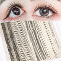 Segmented false eyelash kit open showing lashes, pink and black glue pots, tweezers, and an applicator brush.