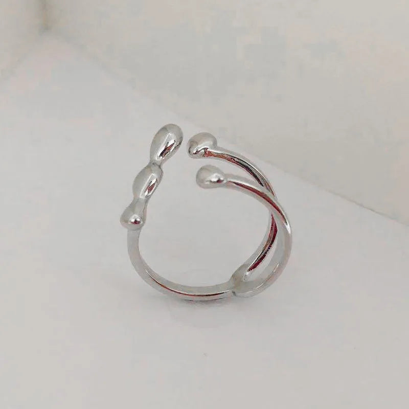 Brass ring with a spherical design on a circular band, shown in gold and silver finishes.