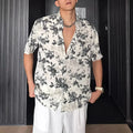 White loose-fit short sleeve casual shirt with a floral print and an open cardigan style front.