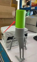 Green and grey automatic Stirr utensil for hands-free mixing in a cooking pot.