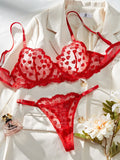 Women's red mesh two-piece suit set with top and trousers on a hanger.