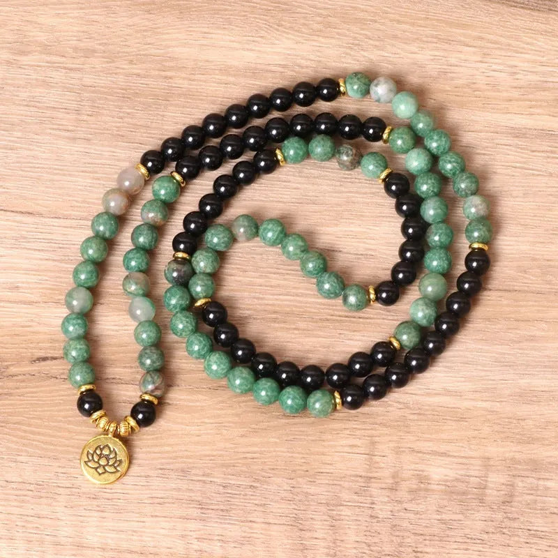 Long elastic bracelet with green and black alloy charms and natural style beads on a stretch band.