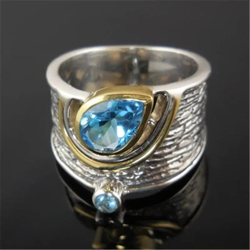 Blue zircon stone set in a drop-shaped alloy ring with Chinese style design.