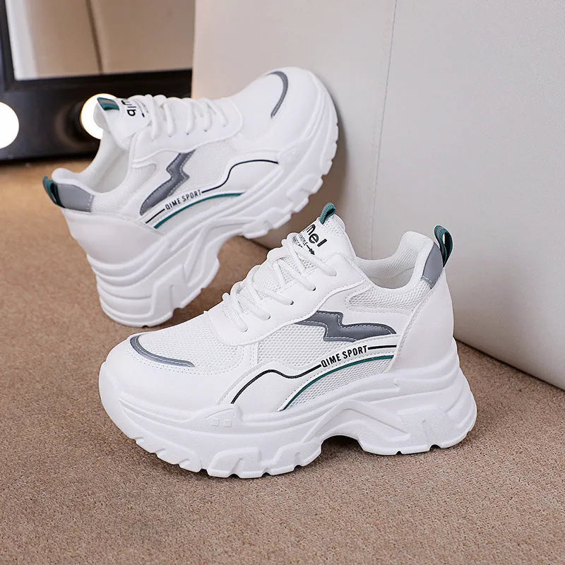 Women's white low-top sports trainers with cross shoulder straps and front laces, made of breathable mesh.