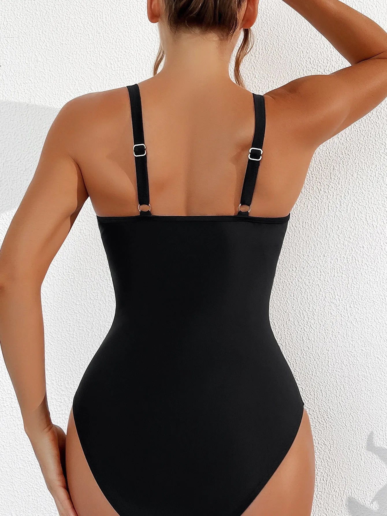 Black halter neck one-piece swimsuit with brief-style bottom on a female mannequin.