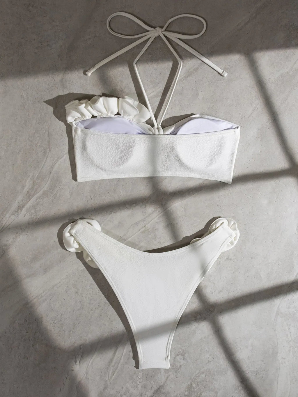 White halter bikini with three-dimensional flower pattern and lace-up detailing