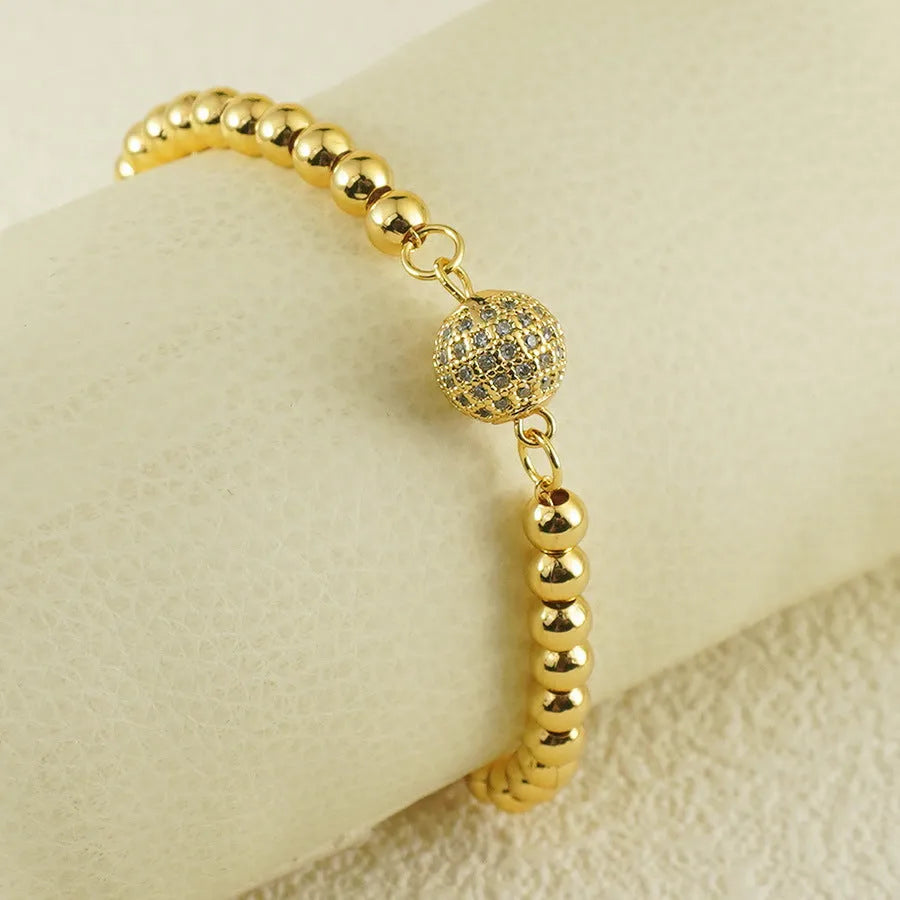 Close-up of a women's copper bracelet with a heart shape and a single round zircon stone in an Arabic-style design.