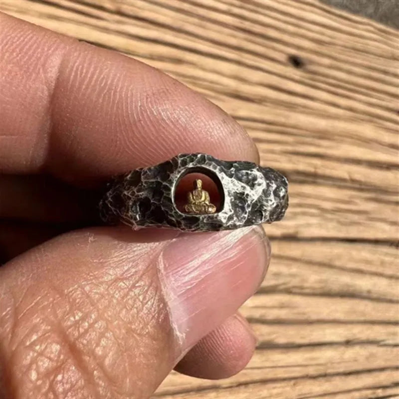 Close-up of a hand-forged copper ring with a Buddha motif and rock texture band on a size 8 finger.