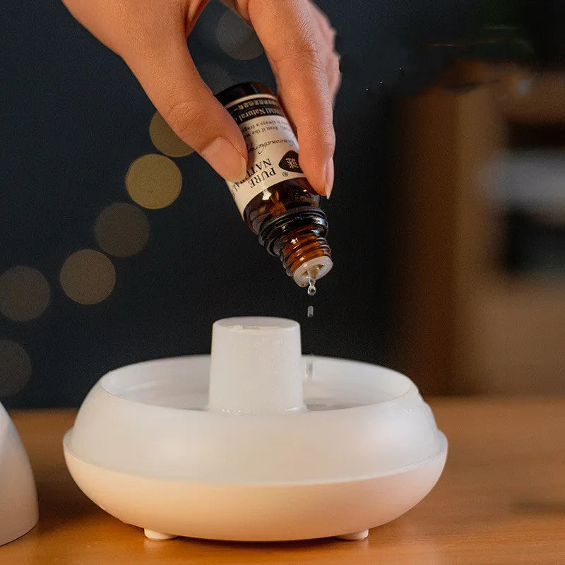 Black flame humidifier aroma diffuser with 130ml tank, 7 colour lights, and USB power on a wooden table