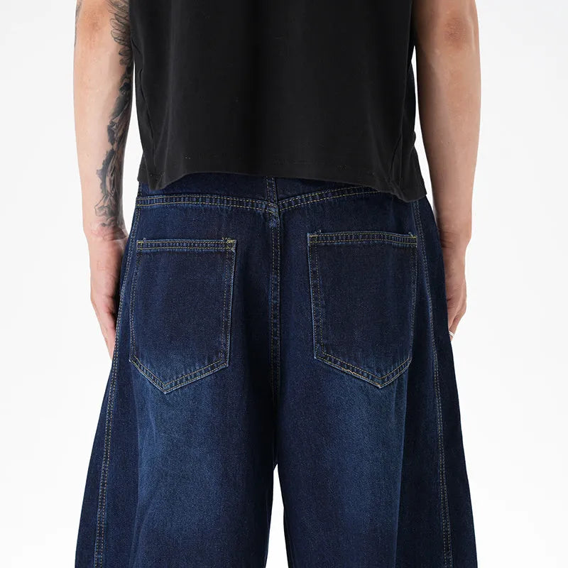 Dark blue wide-leg jeans with a distressed wash on a denim fabric, showing a relaxed fit.