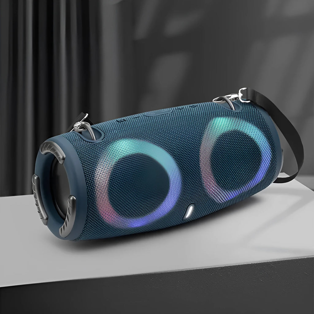 War Drum portable Bluetooth speaker with coloured RGB lights on a table outdoors.
