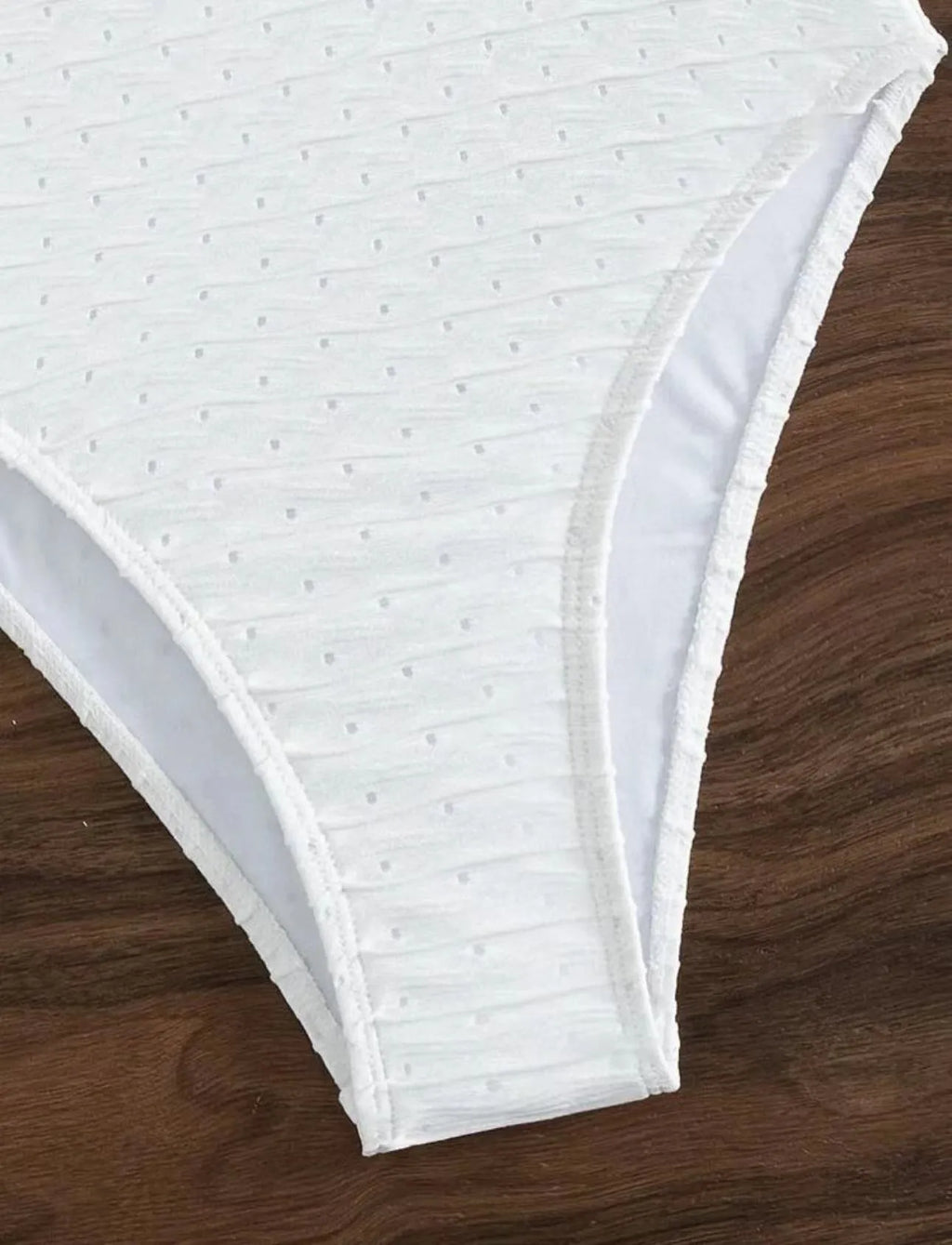 White women's one-piece swimsuit with a sling-style design made from high-elasticity polyester fabric.
