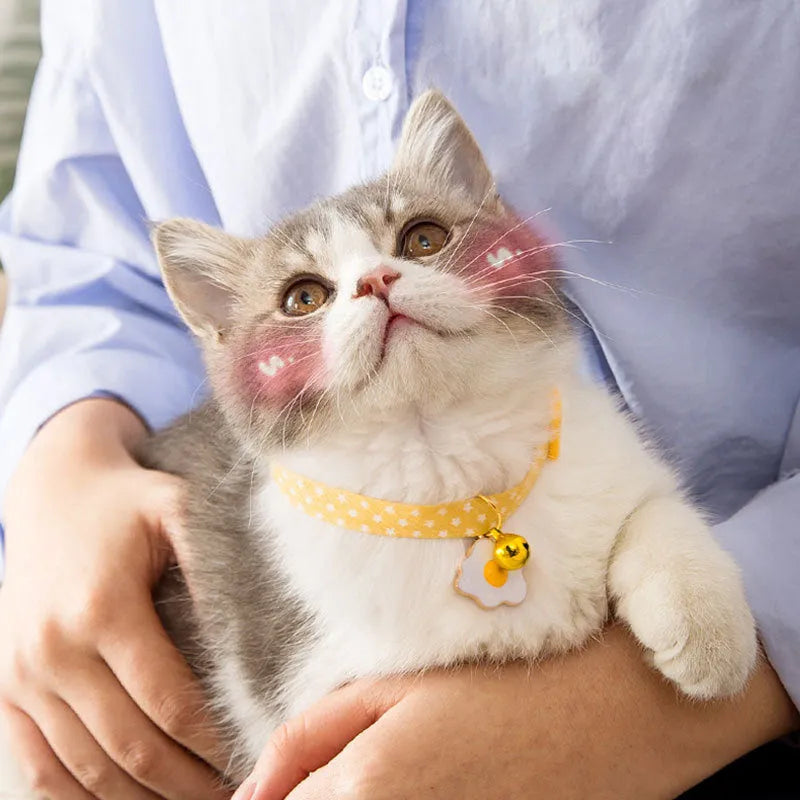 Adjustable green cat collar with a metal bell pendant and a matching bow tie decoration.