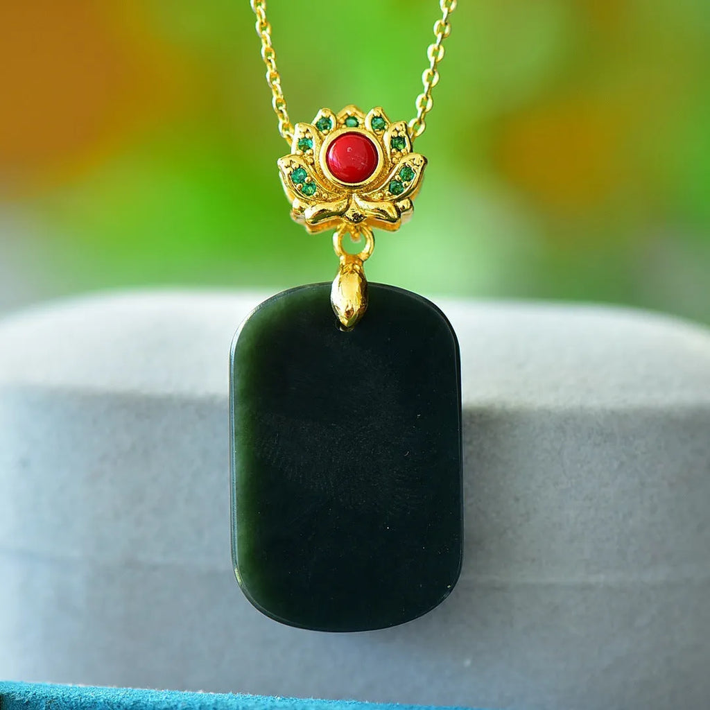 Flat disc pendant of grey and ink blue Hetian Jade with a decorative copper inlay on a necklace chain.