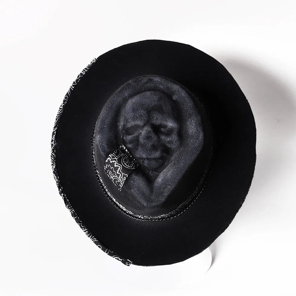 Handmade black and white skull print pointed witch hat on a wooden surface