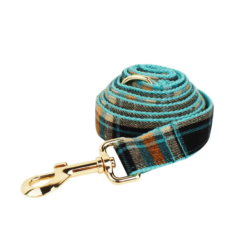 Green retro style cloth dog collar, leash, vest, and decorative bow set laid out flat.