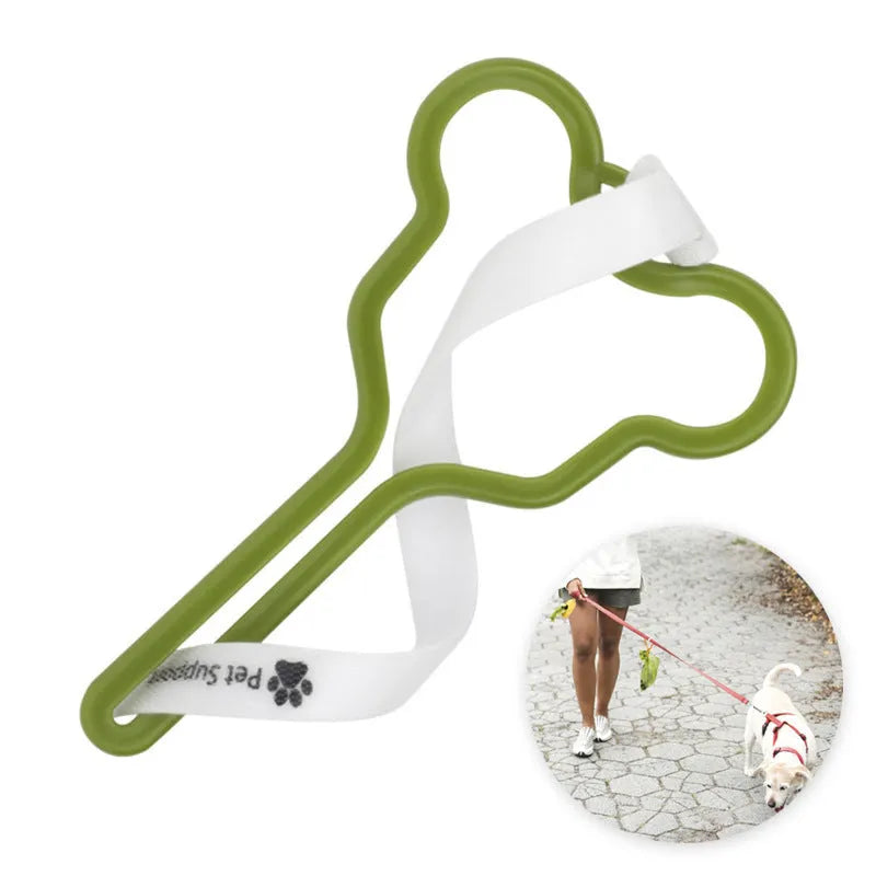 A hands-free dog poop bag holder with a black plastic clip and adjustable velcro strap, loaded with green waste bags.
