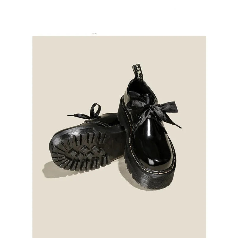 Women's black thick soled leather shoes with cross strap and ribbon lacing closure