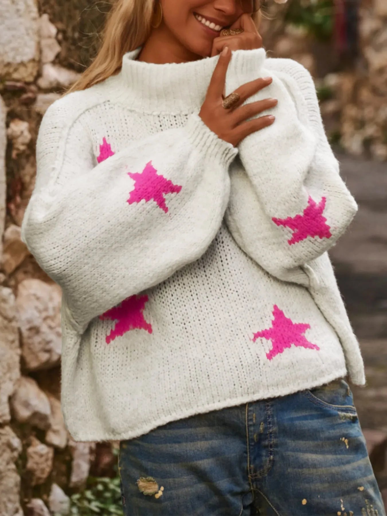 White women's loose turtleneck pullover with a black five-pointed star pattern on the front.