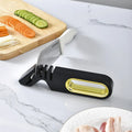 Four-in-one stone manual grinder for sharpening kitchen knives in pearl white colour, with ceramic and diamond stages visible