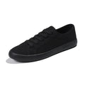 Women's all-black canvas flat lace-up shoes with a slim profile and rubber sole.