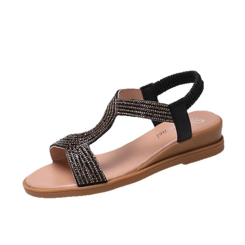 Gold women's patent leather sandals with rhinestones and a round toe on a non-slip sole.