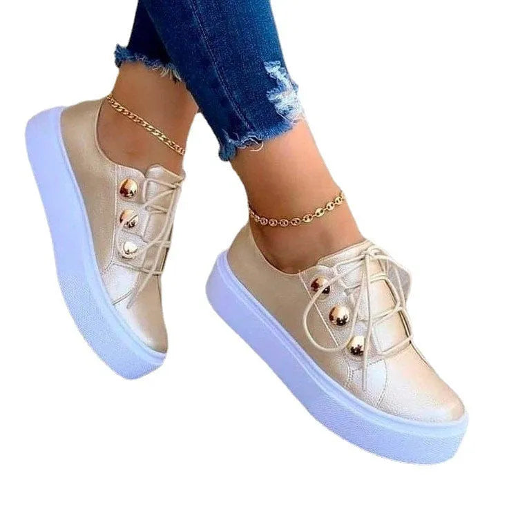 Women's white lace-up flats sneakers with decorative silver rivets on the artificial PU upper.