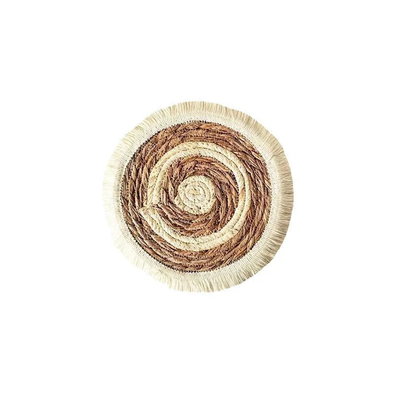 Round natural papyrus placemat on a wooden table, showing corn rope tassel detail and modern minimalist style.